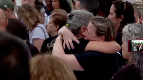 Two group hug astatine an arena remembering victims of Hamas's 7 October onslaught connected Israel