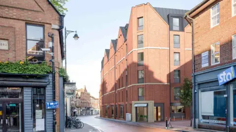 Marick Real Estate The design of the new building from George Street, showing a building taller than the current one, with triangular-shaped grey rooftop. The entrance of the new hotel is facing George Street