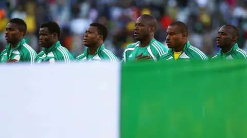 Nigeria players line up behind their flag for their national anthem during the 2010 FIFA World Cup South Africa 