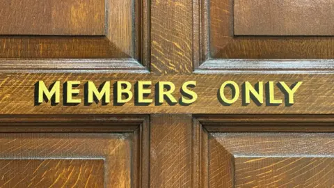 Letras doradas en una puerta que dicen "Solo para miembros".