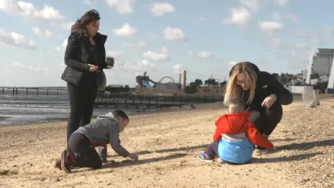 Jamie Niblock/BBC Julie Noble and Hayley Webb playing with children on Southend beach