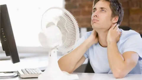 Getty Images Man next to fan