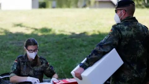 Reuters German soldiers in masks preparing to test people in Guetersloh