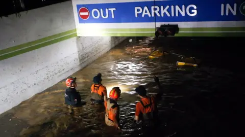 KIM HEE-CHUL/EPA Firefighters and military officials search in an underground parking lot of an apartment in Nam-gu