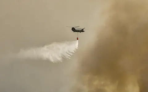 AFP A military Chinook helicopter flies over the area of Magoula, near Athens, Greece