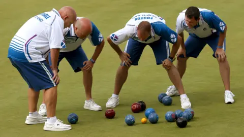 Alex Marshall, Paul Foster, Neil Speirs i David Peacock z PA Media Scotland oglądają strzał przeciwko Anglii w finale męskiej czwórki w Kelvingrove Lawn Bowls Centre podczas Igrzysk Wspólnoty Narodów 2014 w Glasgow.