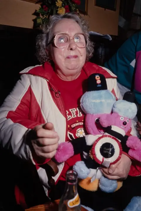 Bill Stephenson A woman holding a Bertie Bassett doll