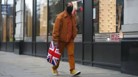 Getty Images Man shopping wearing a face mask