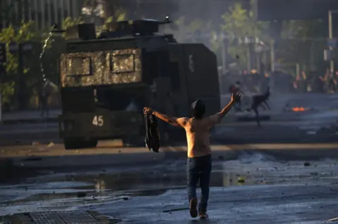 Getty Images A man confronts a tank at protests in Chile