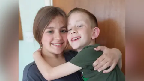 Kieran Chatten Emilia, 13, and Jakub, 8, hugging each other