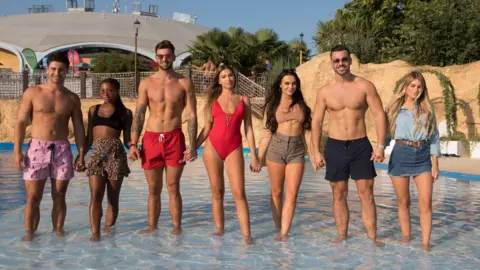 PA Frankie, Samira, Adam, Zara, Rosie, Alex Miller and Haley from Love Island ankle-deep in water at Thorpe Park