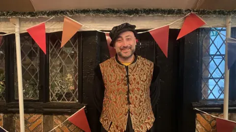 Man with small beard wearing Tudor tunic and hat