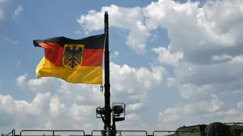 CHRISTOF STACHE/AFP The German flag flies on a military vehicle at the military base of Kaufbeuren, southern Germany, during an Open Day of Germany's armed forces, the Bundeswehr, on June 17, 2023.
