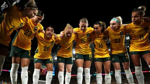 Getty Images Sam Kerr fala com sua equipe em um amontoado antes de uma partida da Copa do Mundo em Sydney em 2023