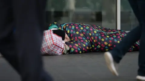 PA Media A man sleeping on the street in a sleeping bag