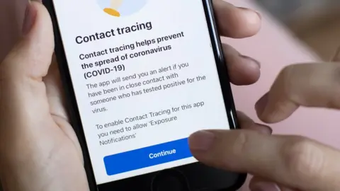 Getty Images A person uses the NHS Covid-19 app in England