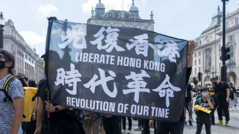 Getty Images Protestors hold up a banner that says Liberate Hong Kong