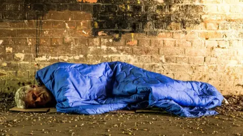 Getty Images Man sleeping on street