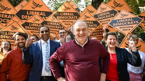 Getty Images Liberal Democrat leader Ed Davey with party members waving placards