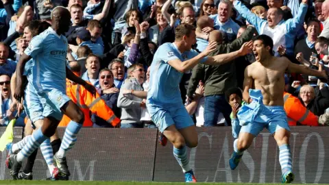 Reuters Manchester City's Sergio Aguero (right) celebrates his winning goal with team mates Mario Balotelli (left) and Edin Dzeko (centre)