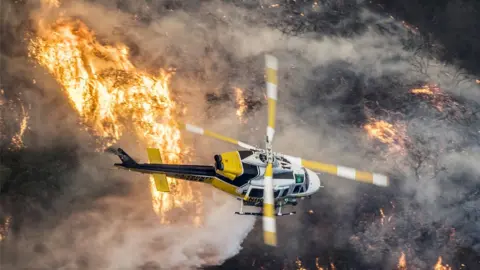 EPA A helicopter flies over wildfires.