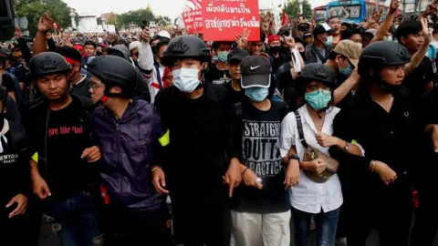 Reuters Pro-democracy demonstrators make a human chain as they march during a Thai anti-government mass protest, on the 47th anniversary of the 1973 student uprising, in Bangkok, Thailand October 14, 2020.