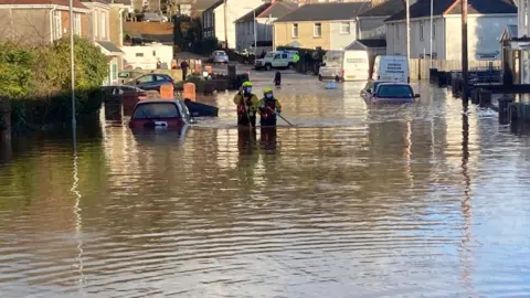 Firefighters waded through water up to their thighs amidst reports of evacuated homes in Skewen