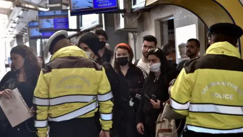 Getty Images A policeman, wearing a face mask for protect from coronavirus, check documents verifying purpose of movement during the coronavirus disease (COVID-19) outbreak on 17 April