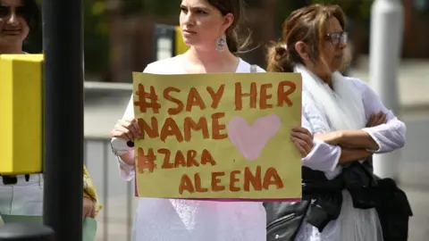 PA Media Woman holding sign