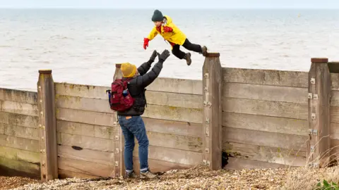 Getty Images Man catches a jumping boy