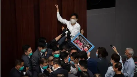 EPA Pro-democracy lawmaker Eddie Chu Hoi-Dick (C) tries to climb a wall during a House Committee at the Legislative Council in Hong Kong, China, 08 May 2020.