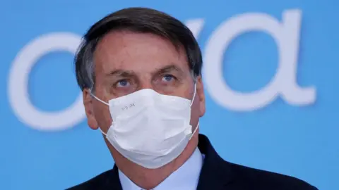 Reuters Brazil"s President Jair Bolsonaro wearing a protective mask looks on during the launching ceremony of the Plano Safra 2020/2021, an action plan for the agricultural sector, in Brasilia, Brazil, June 17, 2020