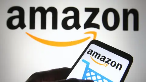 Getty Images The Amazon logo is seen on a smartphone and a pc screen