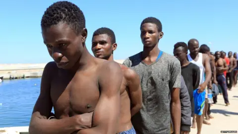 Getty Images Illegal immigrants from Africa, lined up on the way to a detention centre in Libya