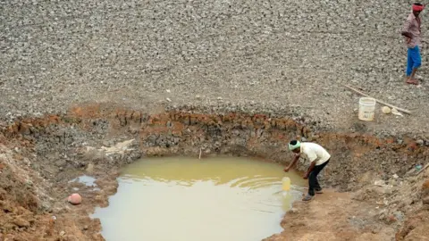 Getty Images Indian workers collect water from the Puzhal reservoir on the outskirts of Chennai on June 20, 2019. - Water levels in the four main reservoirs in Chennai have fallen to one of its lowest levels in 70 years, according to local media reports