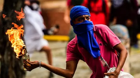 AFP An opposition demonstrator prepares to throw a molotov cocktail during clashes with riot police in an anti-government protest in Caracas