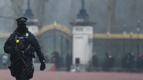 Getty Images A Met police officer with a machine gun and his face covered standing outside