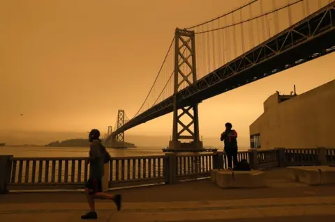EPA A view of the San Francisco Bay Bridge under an orange overcast sky in the afternoon in San Francisco, California, USA, on 9 September 2020