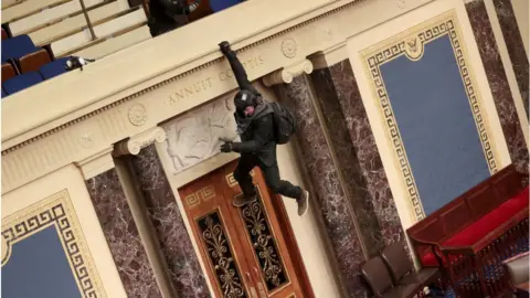 Getty Images Officials have named the dangling rioter above as Josiah Colt of Idaho