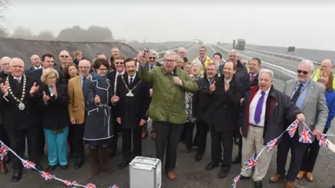 Norfolk County Council Broadland MP Keith Simpson cuts the ribbon to the final section of road