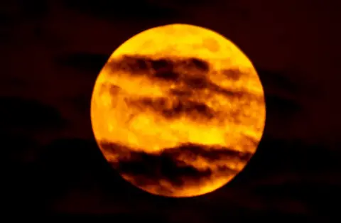 David Greer A picture of the blood man taken in Dubai, UAE, shows red-tinged clouds across a bright orange moon