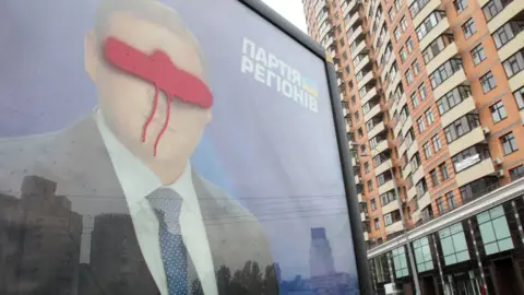 ANATOLII STEPANOV/AFP/GETTY IMAGES Defaced billboard of Mykhaylo Dobkin