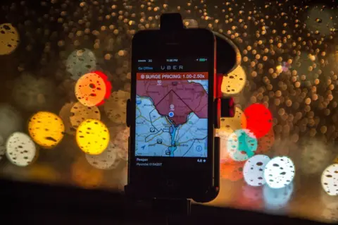 Getty Images The Uber driver app on the windshield of a car showing surge pricing is in effect in Washington DC