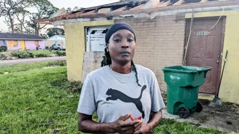 BBC Crystal Coleman stands in front of the ruins of her home in south Florida 