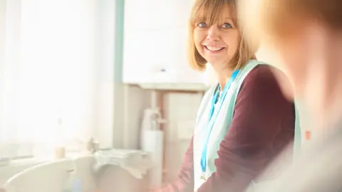 MartinPrescott/Getty Images Care worker in home (generic)