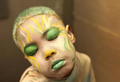 Reuters Junior Lambrechts has his face painted in preparation for the Cape Minstrel Carnival in Cape Town, South Africa January 2, 2023
