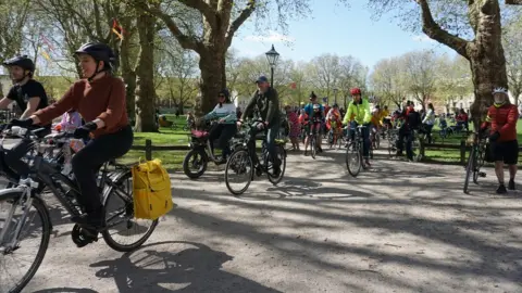 Bristol Cycling Riders cycle through Queen Square in the centre of Bristol