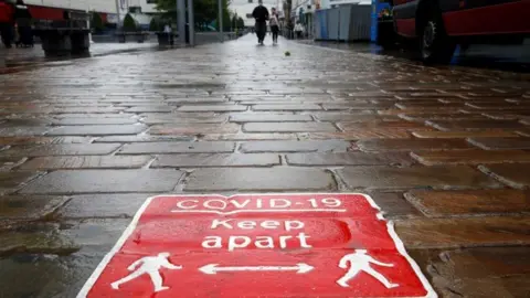 Reuters Covid social distancing sign in Blackburn cobbled street