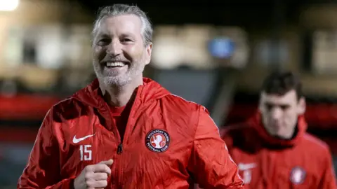 Robbie Savage warming up with Stockport Town