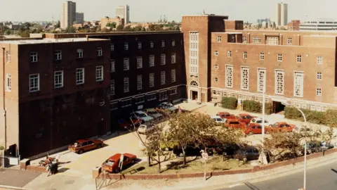 University of Portsmouth old photo of large building with cars in front